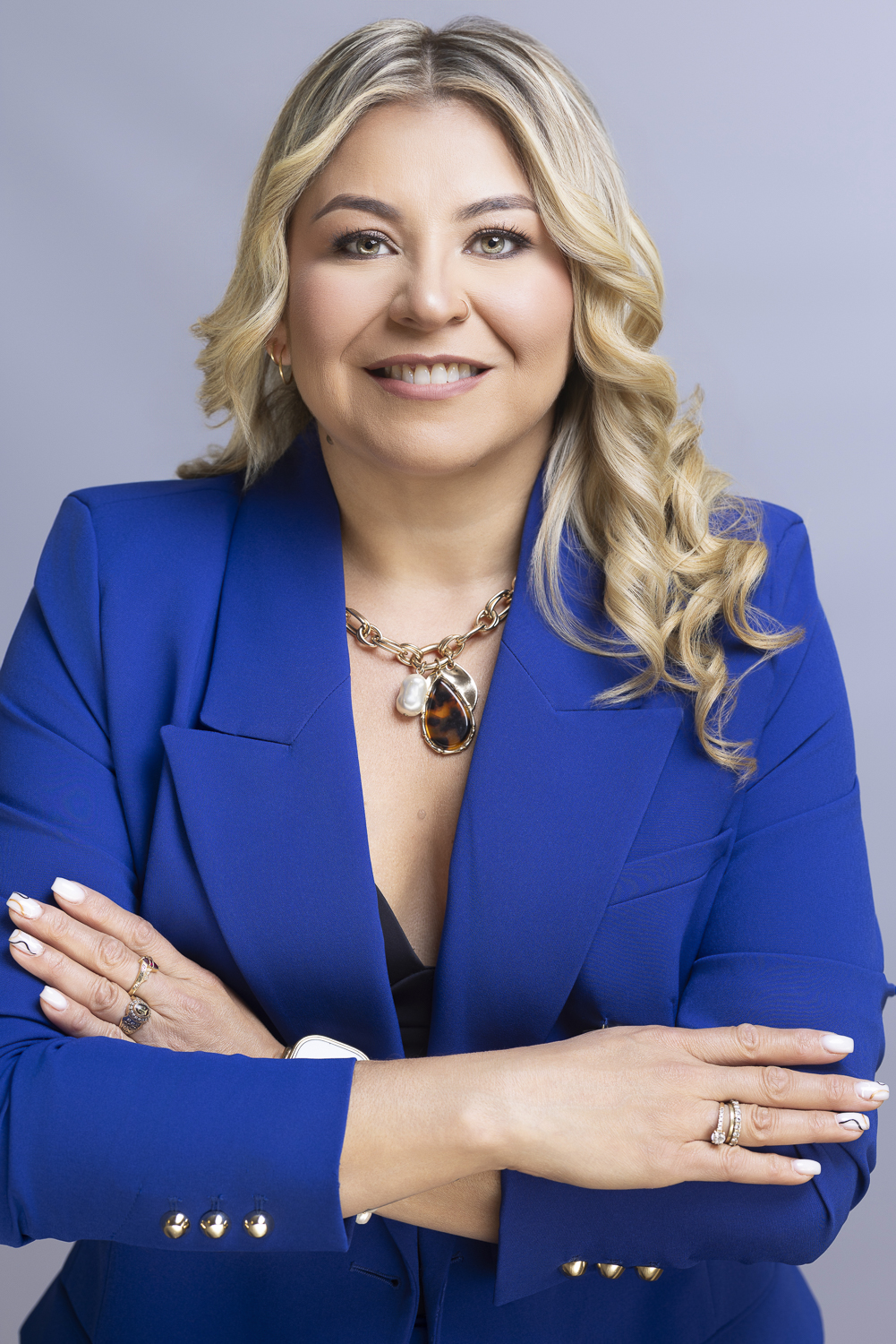 Preparadora de formularios de AC Forms Assistance sonriendo, con saco azul y brazos cruzados